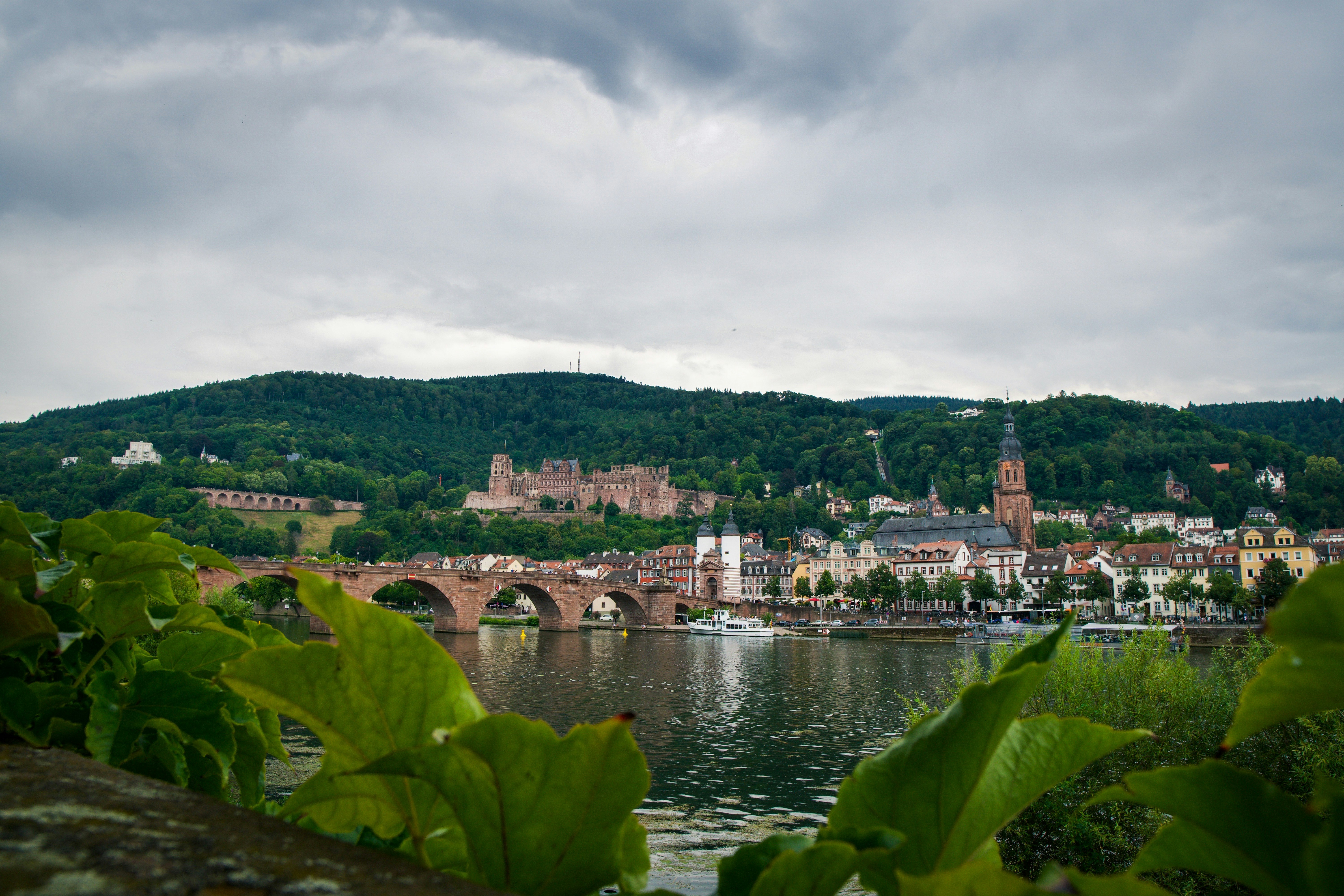 body of water near city buildings under cloudy sky during daytime